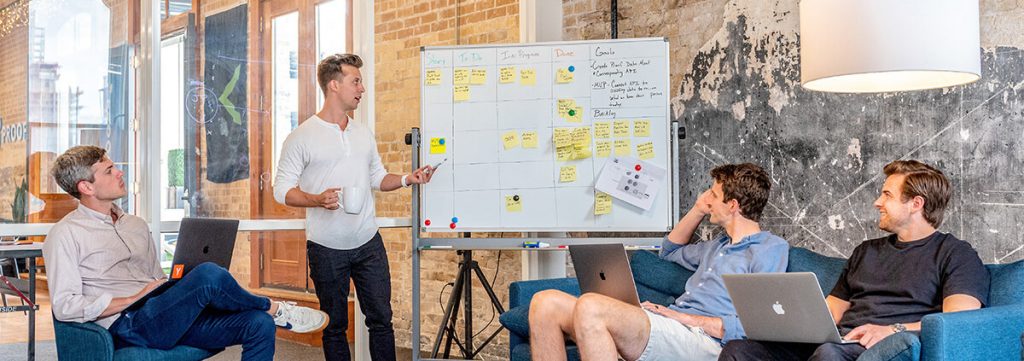 men in front of a whiteboard