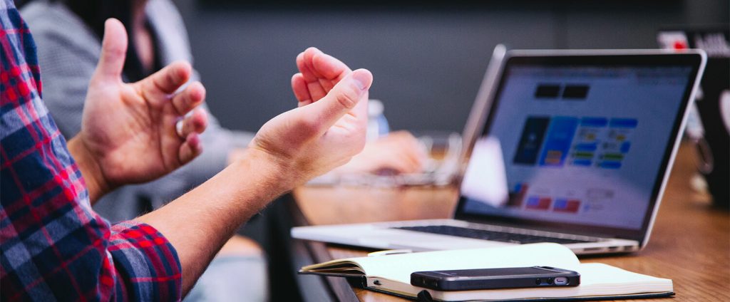 stock shot, mans hands in explanation in front of a laptop