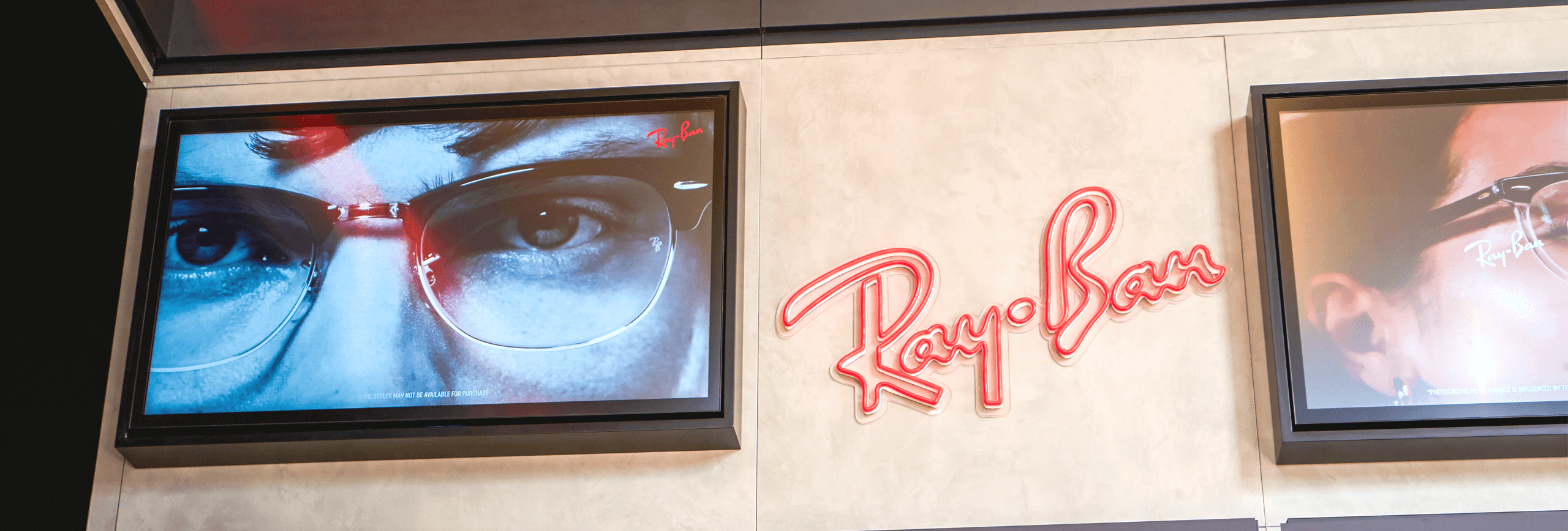Inside the EssilorLuxottica Eyehub store showing digital screens with Rayban brand content